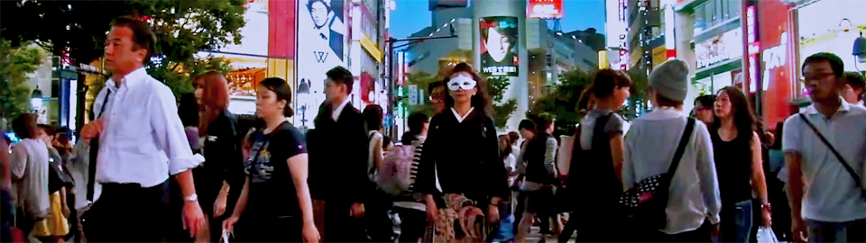 人で溢れる渋谷の交差点に立ち、こちらを見る、マスクをつけて着物を着た女性 PV「黒留NIGHT」の一場面 クリックすると動画が再生されます。